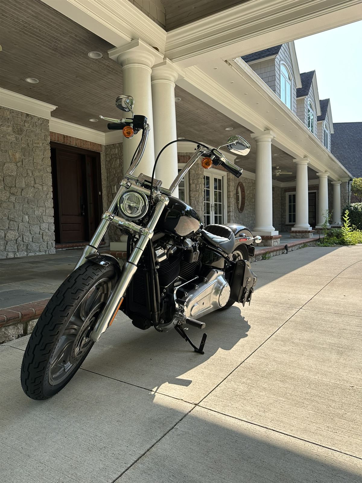 Harley-Davidson Softail with ape hangers parked under a stone portico